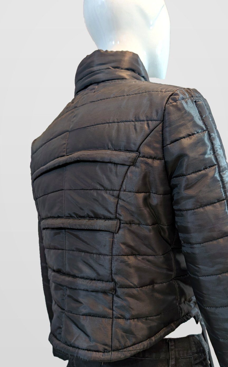 Black Nova Puffer back view showing quilted panels on a mannequin, framed just below the jacket hem